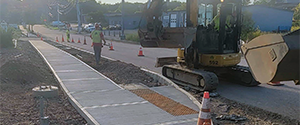 Grading the green space between the curb and the newly placed concrete sidewalk on Sears Lane.
