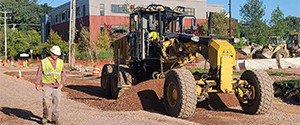 Grading the green space between the curb and the newly placed concrete sidewalk on Sears Lane.