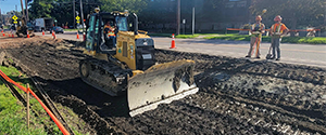 Grading the shared use path along Pine Street in preparation for the installation dense grade subbase material.
