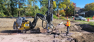 Crews drilling in preparation for blasting to remove ledge along the east side of Briggs Street just south of Flynn Avenue.