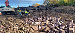 Blasted ledge for removal along the east side of Briggs Street just south of Flynn Avenue. Protective blasting mats pictured in the background.