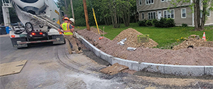 Placing concrete support to the granite curb along the corner of Batchelder Street and Morse Place.